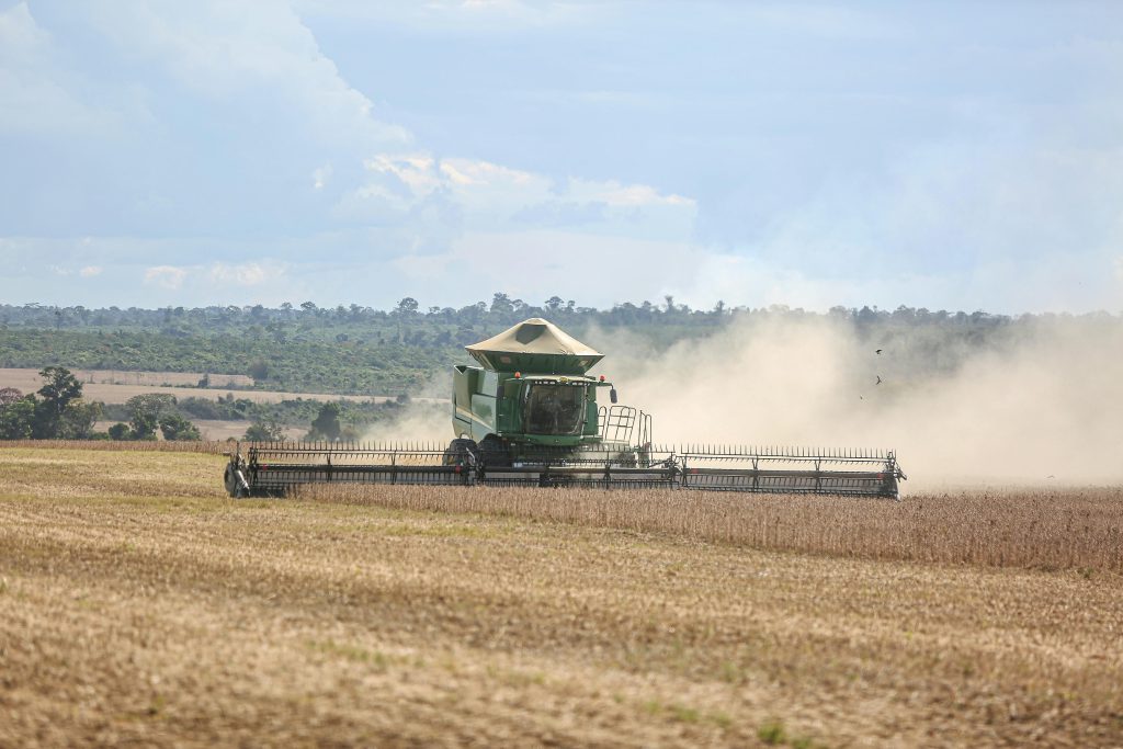 A combine harvester works on a vast soybean field in Paragominas, capturing Brazilian agriculture.